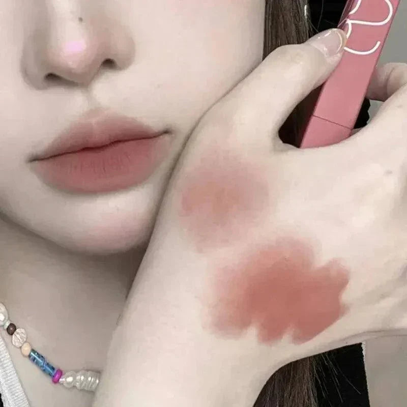 rossetto opaco impermeabile a tubo sottile color rosa su labbra e mano di donna
